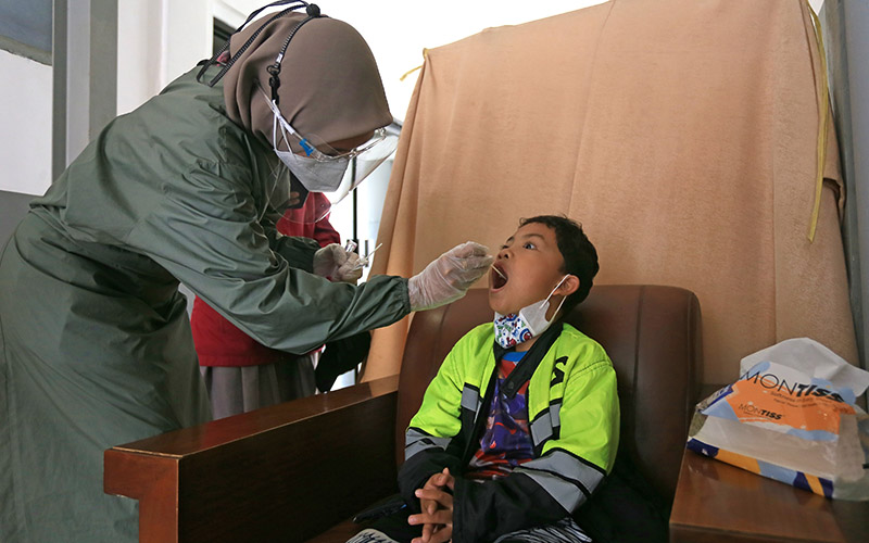 Petugas melakukan tes PCR kepada penumpang anak-anak sebelum melakukan perjalanan kereta api di Stasiun Jatibarang, Indramayu, Jawa Barat, Sabtu (25/12/2021). /Antara Foto-Dedhez Anggara-YUrn