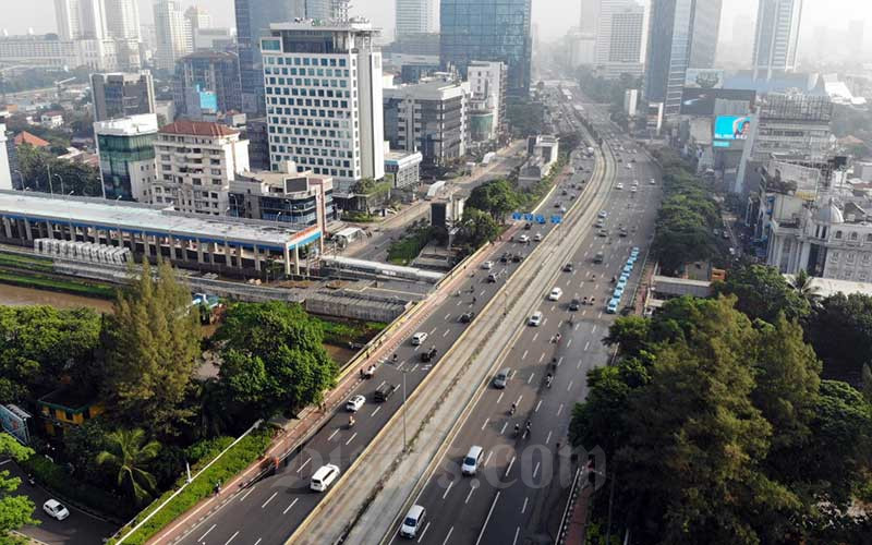 Kendaraan melintas di Jalan Sudirman saat diberlakukan Pembatasan Sosial Berskala Besar (PSBB) di Jakarta, Senin (13/4/2020). Bisnis/Himawan L Nugraha
