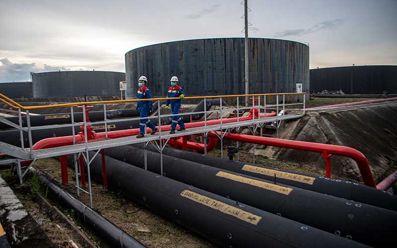 Pekerja PT Pertamina Hulu Rokan mengecek saluran pipa minyak yang menuju tangki pengumpul produksi minyak (Tank Farm) di Blok Rokan, Dumai, Riau, Rabu (22/12/2021). ANTARA FOTO/Nova Wahyudi