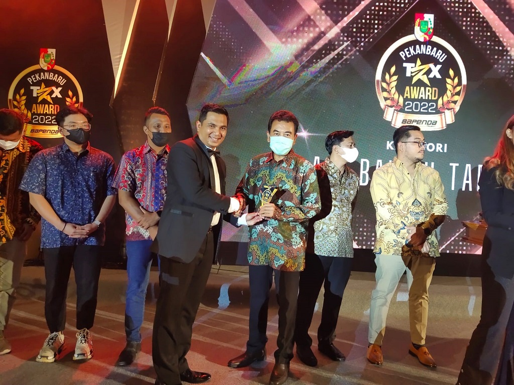 Foto: Kepala Bapenda Pekanbaru Zulhelmi Arifin (kiri) menyerahkan trofi Pekanbaru Tax Award 2022 kepada perwakilan PT Pertamina Hulu Rokan dalam sebuah acara yang berlangsung di SKA CoEx, Pekanbaru, pada Rabu (18/5). 