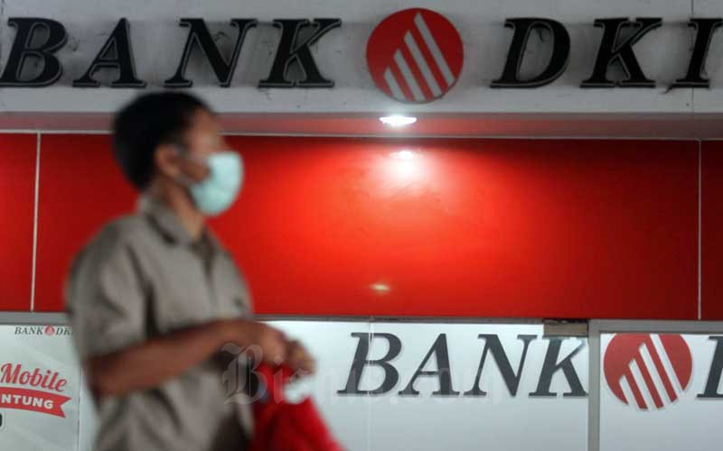 Warga melintas di depan logo Bank DKI di Jakarta, Selasa (5/5/2020). /Bisnis-Arief Hermawan P