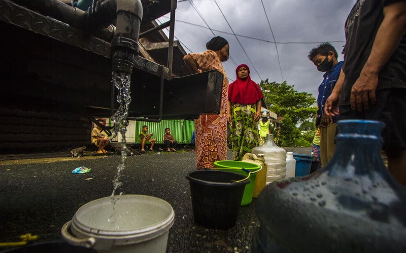 Sejumlah warga antre untuk mendapatkan air bersih di Kelurahan Pelambuan, Banjarmasin, Kalimantan Selatan, Minggu (15/5/2022). Warga di daerah tersebut kesulitan mendapatkan air bersih akibat pasokan dari Perusahaan Daerah Air Minum (PDAM) Banjarmasin mengalami penurunan bahkan tidak mengalir sejak dua bulan terakhir sehingga warga terpaksa menggunakan air aliran sungai serta membeli air bersih untuk memenuhi kebutuhan sehari-hari./Antara-Bayu Pratama S.