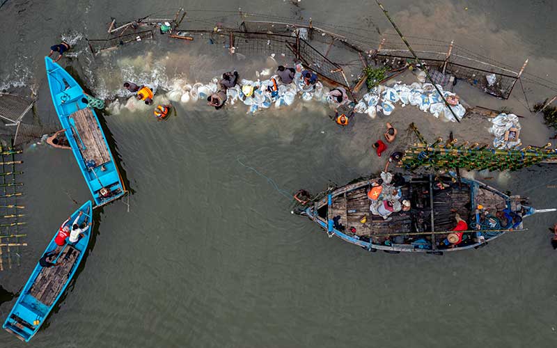  Warga Bergotong Royong Menutup Tanggul Yang Jebol di Kawasan Industri Pelabuhan Tanjung Emas