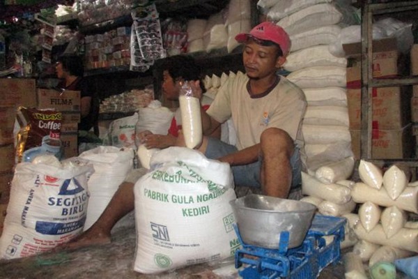 Pekerja sedang menimbang gula yang dkemas dalam plastik di Pasar legi, Solo, Selasa (10/5). JIBI/SOLOPOS/Sunaryo Haryo Bayu