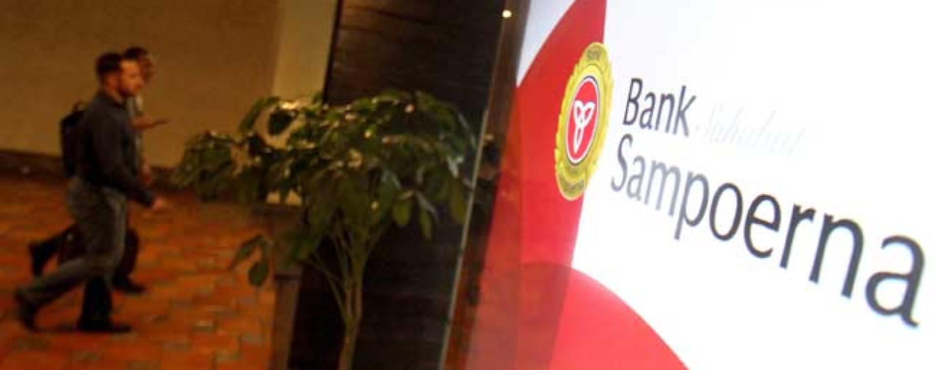 Pengunjung melintas didekat logo Bank Sampoerna di Jakarta. Bisnis/Arief Hermawan P