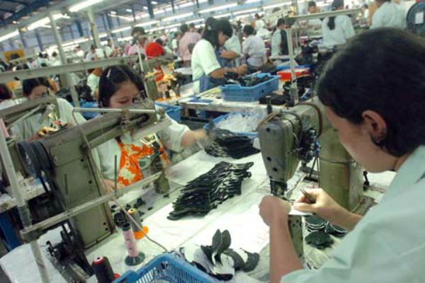 Pekerja pabrik menyelesaikan proses produksi sepatu. /Ilustrasi-Bisnis.com-WD