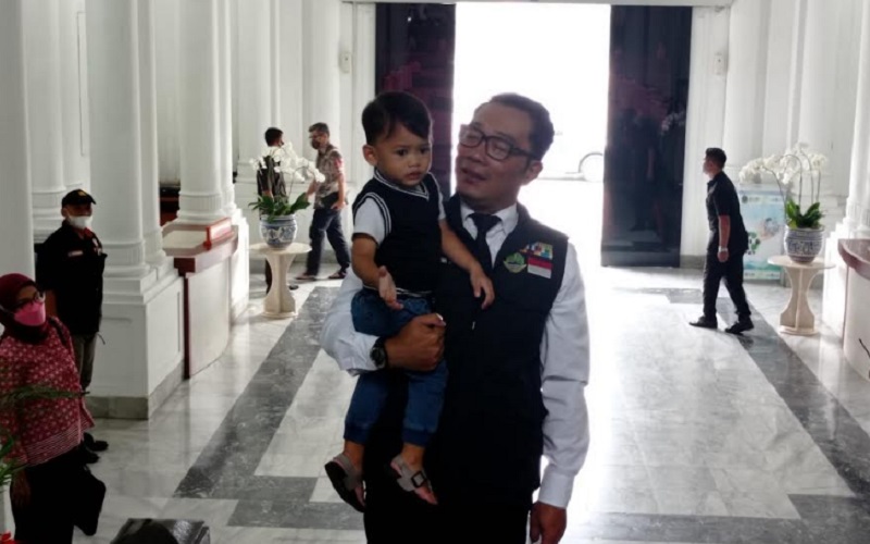Gubernur Jawa Barat Ridwan Kamil saat menggendong putra bungsunya Arka untuk memulai aktivitas kerjanya hari ini di Gedung Sate./Bisnis-Wisnu Wage