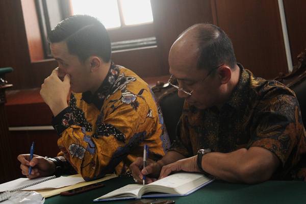 Direktur Utama PT Merpati Nusantara Airlines (Persero) Asep Ekanugraha (kanan) didampingi kuasa hukum Rizky Dwinanto (kiri) mendengarkan pembacaan putusan hakim saat sidang Penundaan Kewajiban Pembayaran Utang (PKPU) di Pengadilan Negeri (PN) Surabaya, Jawa Timur, Rabu (14/11/2018)./Antara