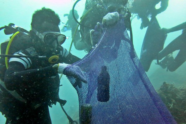 Penyelam mengumpulkan botol-botol bekas di dasar laut saat melakukan aksi besih sampah bawah laut dalam rangka menyambut peringatan Hari Bumi, di Kupang, NTT, Jumat (21/4)./Antara-Kornelis Kaha