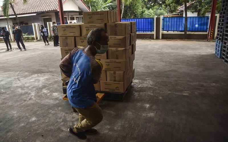 Seorang petugas menata barang di gudang logistik Gedung Departemen Sosial, Bekasi, Jawa Barat, Selasa (14/12/2021). Logistik tersebut akan didistribusikan ke lokasi bencana gempa bumi di Nusa Tenggara Timur (NTT). ANTARA FOTO/ Fakhri Hermansyah