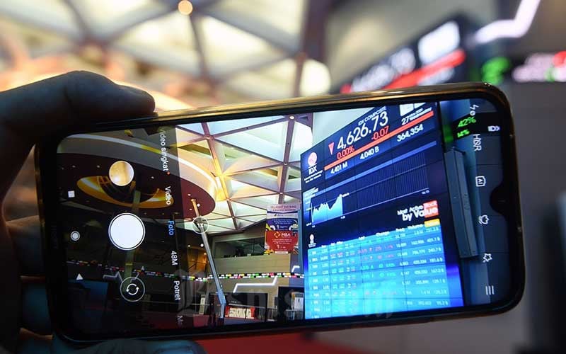 Pengunjung memotret layar monitor perdagangan Indeks Saham Gabungan (IHSG) di Bursa Efek Indonesia, Jakarta. Saham BUMN PGAS dan SMGR mengalami penguatan sehingga turut mendorong Indeks Bisnis-27 hari ini. Bisnis/Abdurachman