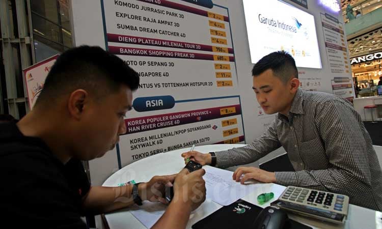 Calon penumpang mencari informasi penerbangan di salah satu pameran wisata di Jakarta, Minggu (1/3/2020). Bisnis/Arief Hermawan P