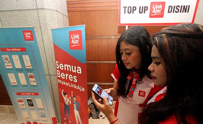 Sales Promotion Girl (SPG) menunjukkan aplikasi LinkAja di Jakarta. Bisnis/Arief Hermawan P