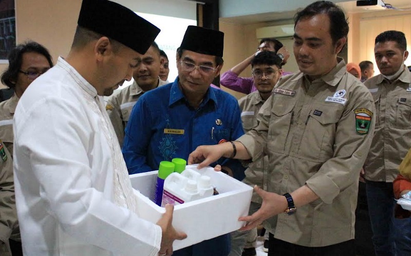 Wakil Gubernur Sumbar Audy Joinaldy (kiri) menyerahkan dosis vaksin dan obat untuk sapi kepada petugas kesehatan hewan yang disaksikan oleh Kepala Dinas Peternakan dan Kesehatan Hewan Sumbar Erinaldi (tengah) di Padang, Jumat (24/6/2022). /Bisnis-Noli Hendra