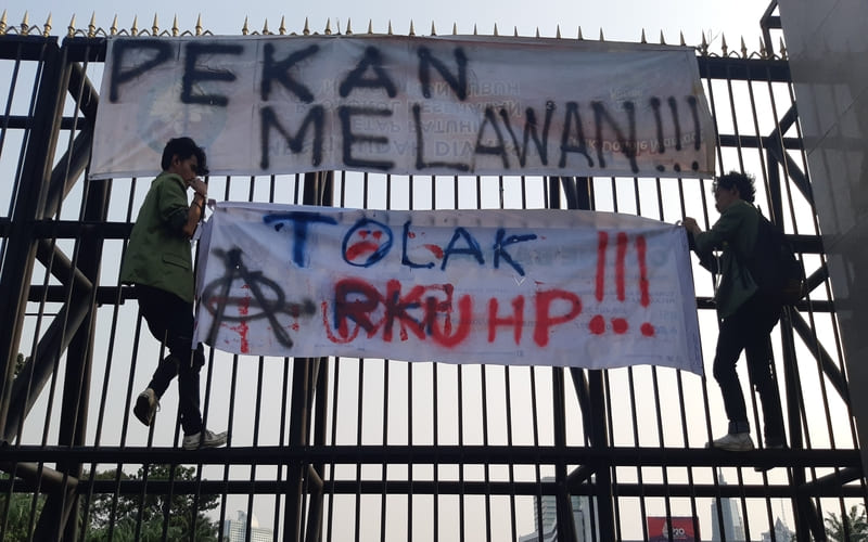 Dua orang mahasiswa memanjat pagat utama Gedung DPR, Senayan, Jakarta, untuk memasang spanduk saat melakukan aksi demonstrasi terkait RKUHP pada Selasa (28/6/2022) - Bisnis.com / Surya Dua Artha Simanjuntak