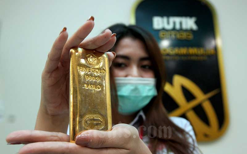 Karyawati menunjukkan replika logam mulia di Butik Emas Antam, Jakarta, Kamis (6/8/2020). Volume emas Antam pada Januari—Mei 2022 berjumlah 11,05 ton, turun 0,62 persen dibandingkan dengan 11,12 ton pada Januari—Mei 2021. Bisnis/Arief Hermawan P