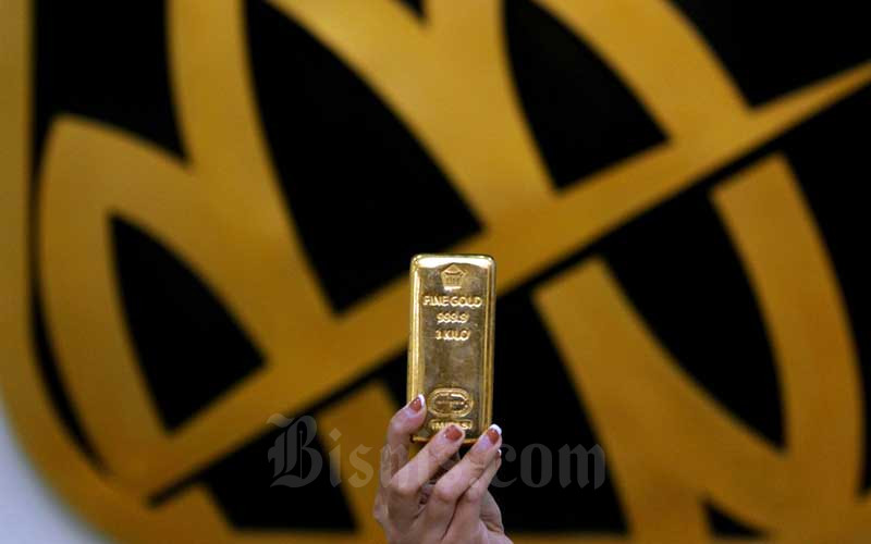 Karyawati menunjukkan replika logam mulia di Butik Emas Antam, Jakarta.. Harga emas 24 karat 1 gram hari ini dibanderol mulai dari Rp900.000-an. Bisnis/Arief Hermawan P