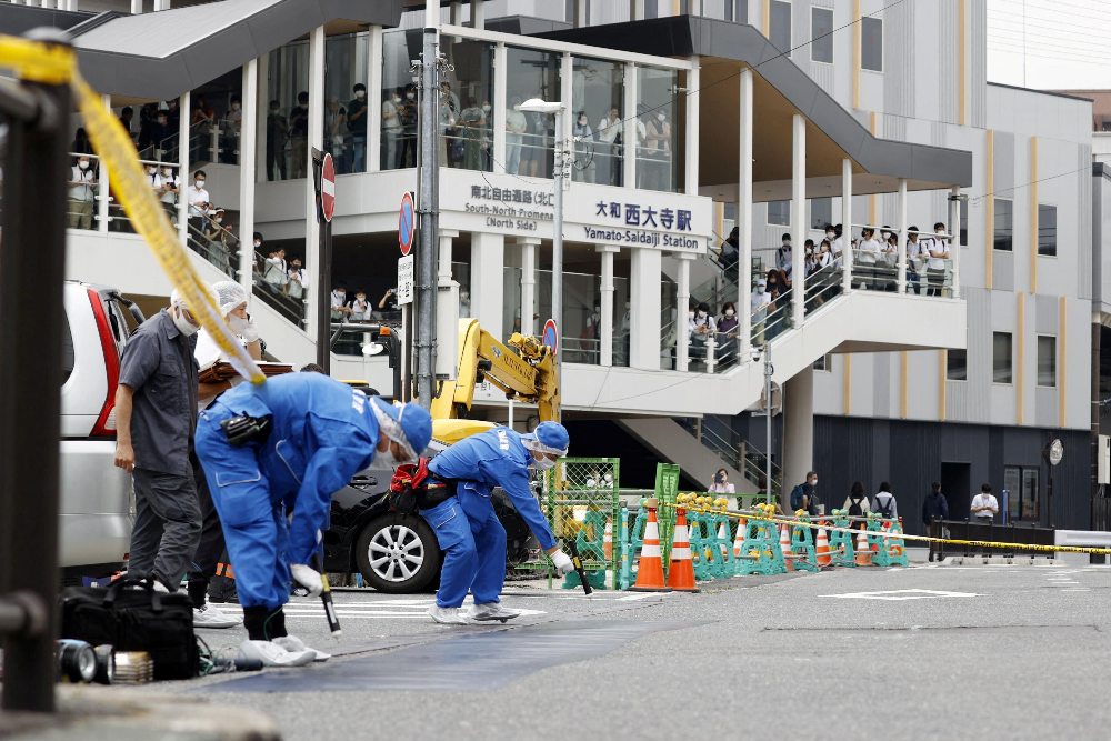 Penyelidik bekerja di sekitar lokasi di mana mantan Perdana Menteri Jepang Shinzo Abe ditembak dari belakang oleh seorang pria selama kampanye pemilihan untuk pemilihan Majelis Tinggi 10 Juli 2022 di Nara, Jepang, Jumat (8/7/2022). Kyodo/via REUTERS