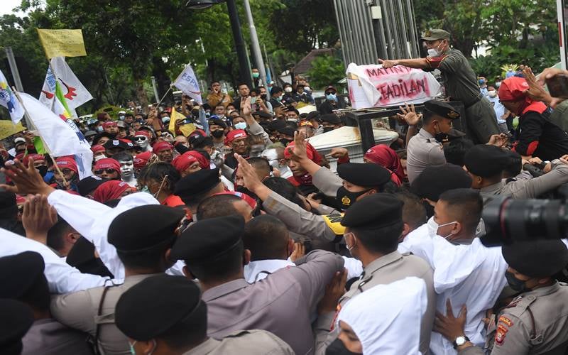 Sejumlah buruh mencoba menerobos pagar saat melakukan aksi unjuk rasa menolak upah minimum provinsi (UMP) di depan Balaikota DKI Jakarta, Senin (29/11/2021). Mereka menolak UMP DKI Jakarta yang hanya naik Rp37.749 atau sekitar 0,8 persen saja dibandingkan tahun lalu. ANTARA FOTO/Akbar Nugroho Gumay/aww.