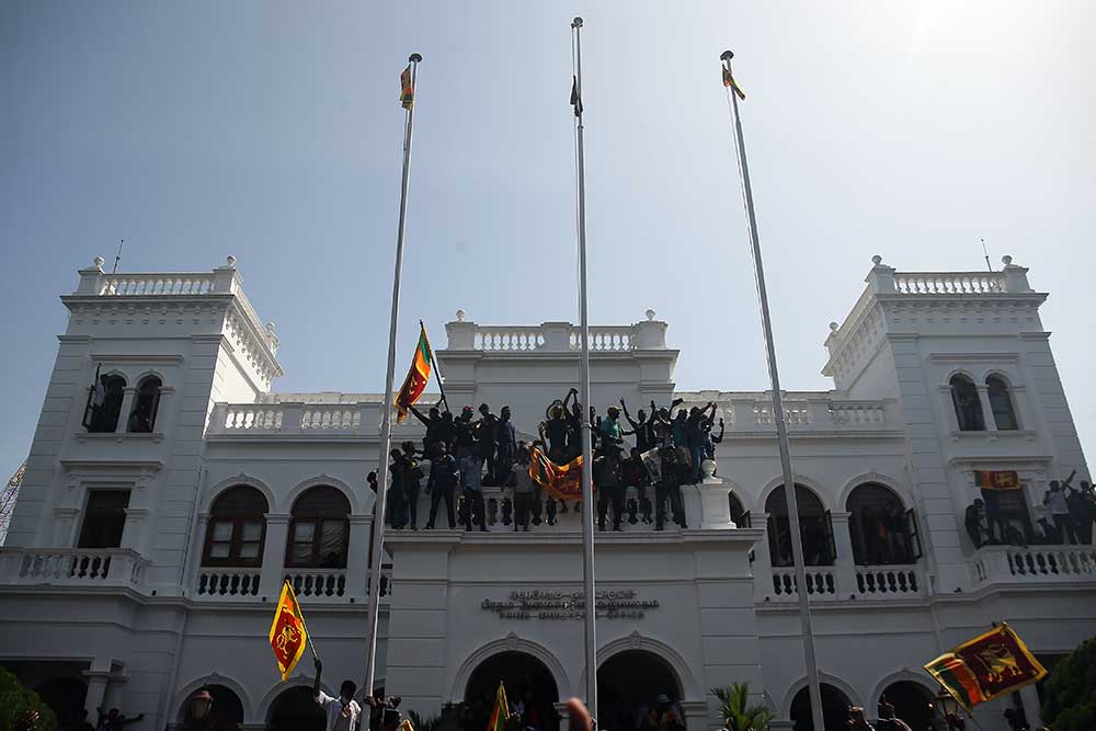 Para pengunjuk rasa menyerbu kompleks kantor perdana menteri, menuntut Ranil Wickremesinghe mengundurkan diri setelah presiden Gotabaya Rajapaksa meninggalkan negara itu di tengah krisis ekonomi di Kolombo, Sri Lanka, Rabu (13/7/2022), Reuters/NurPhoto/Pradeep Dambarage