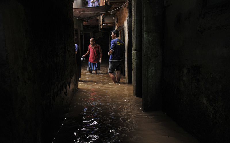 Sejumlah warga melintasi banjir yang menggenangi wilayah Kebon Pala, Jatinegara, Jakarta Timur, Sabtu (16/7/2022). Banjir kiriman akibat meluapnya Sungai Ciliwung yang menggenangi wilayah tersebut berketinggian 30 cm hingga 1,5 meter./Antara-Fakhri Hermansyah.