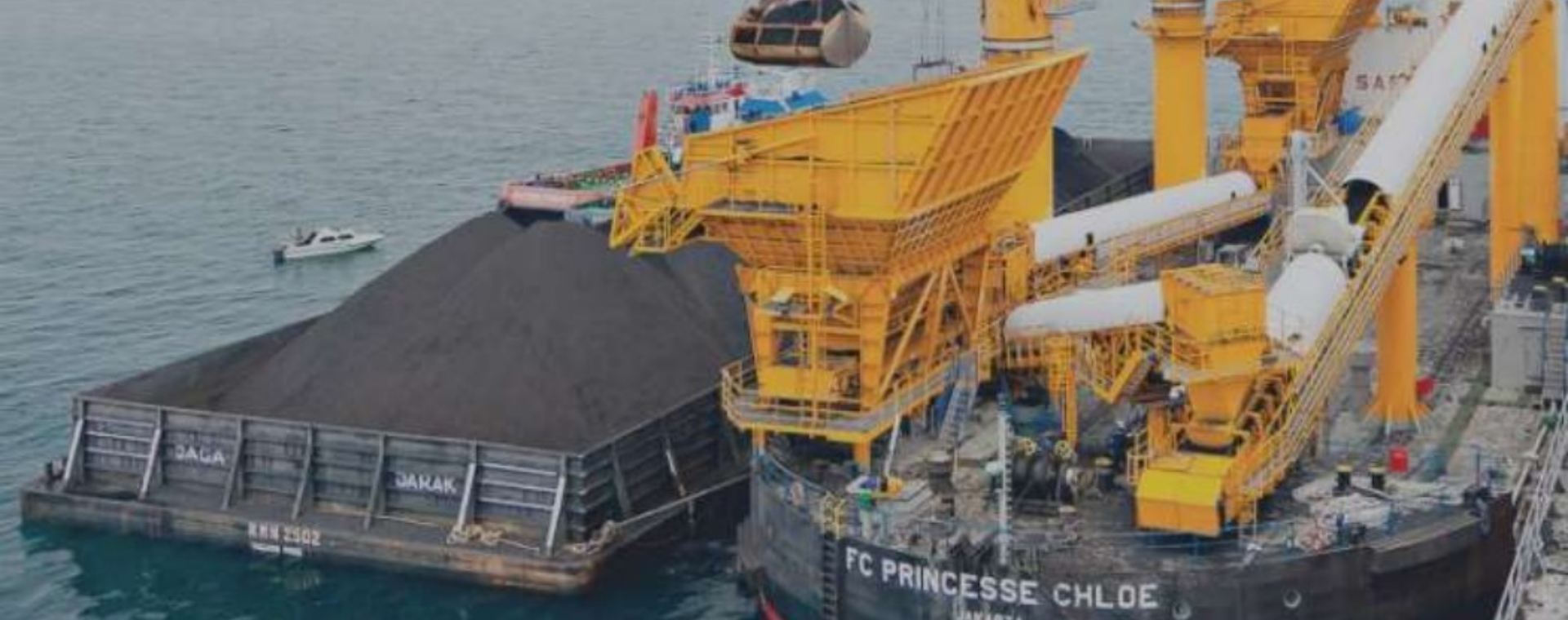 Aktivitas pemindahan muatan batu bara dari tongkang ke kapal induk dengan floating crane oleh anak usaha PT Indika Energy Tbk. (INDY)./indikaenergy.co.idrn