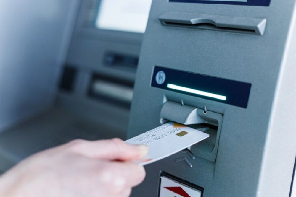 Ilustrasi nasabah menggunakan kartu debit di mesin ATM. /Freepik