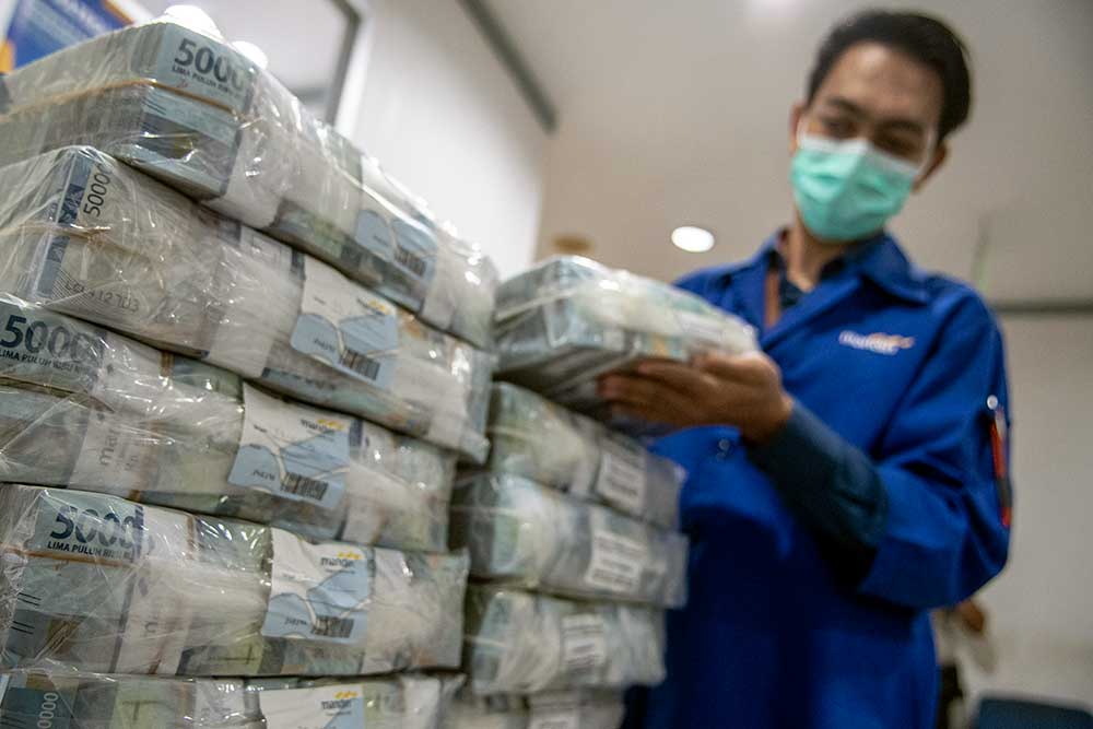 Petugas menyusun tumpukan uang di Cash Pooling Bank Mandiri, Jakarta, Kamis (23/6/2022). ANTARA FOTO/Muhammad Adimaja