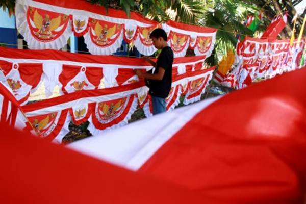 Penjual bendera musiman merapikan dagangannya di Mamuju, Sulawesi Barat, Senin (7/8). Bendera dan umbul-umbul yang dijual dengan harga Rp20.000 hingga Rp500.000 itu mulai marak dijual di sepanjang jalan trans Sulawesi./Antara-Akbar Tado