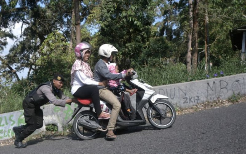 Polisi mendorong sepeda motor warga. /ANTARA