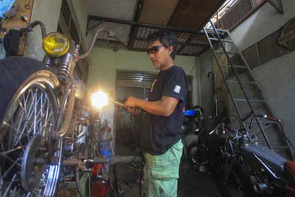 Pegawai bengkel motor custom menyelesaikan perakitan sepeda motor modifikasi yang dipesan pembeli di Bengkel Bre, Solo, Jawa Tengah, Rabu (31/1). /Antara