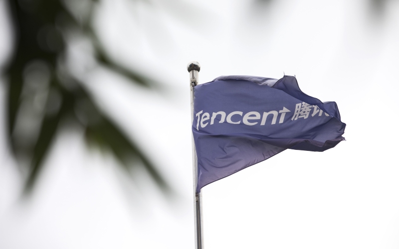 Bendera Tencent Holdings Ltd. berkibar di luar gedung kantor pusat perusahaan tersebut di Beijing, China, Selasa (14/8/2018)./Bloomberg-Giulia Marchi