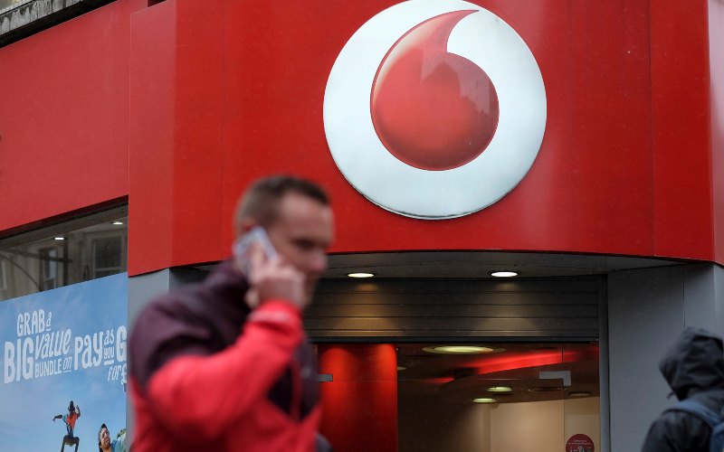 Seorang pria tengah mengangkat telepon di depan gerai Vodafone di London./Simon Dawson/Bloomberg