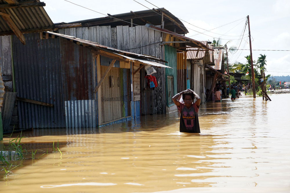 Warga berjalan menerobos banjir untuk mengungsi di kompleks Kokoda Kota Sorong, Papua Barat, Selasa (23/8/2022). BPBD Kota Sorong menyebutkan bencana banjir dan tanah longsor yang terjadi sejak Selasa (23/8) dini hari di wilayah tersebut mengakibatkan dua orang meninggal dunia, satu orang luka berat dan 9.000 KK mengungsi./Antara-Olha Mulalinda.