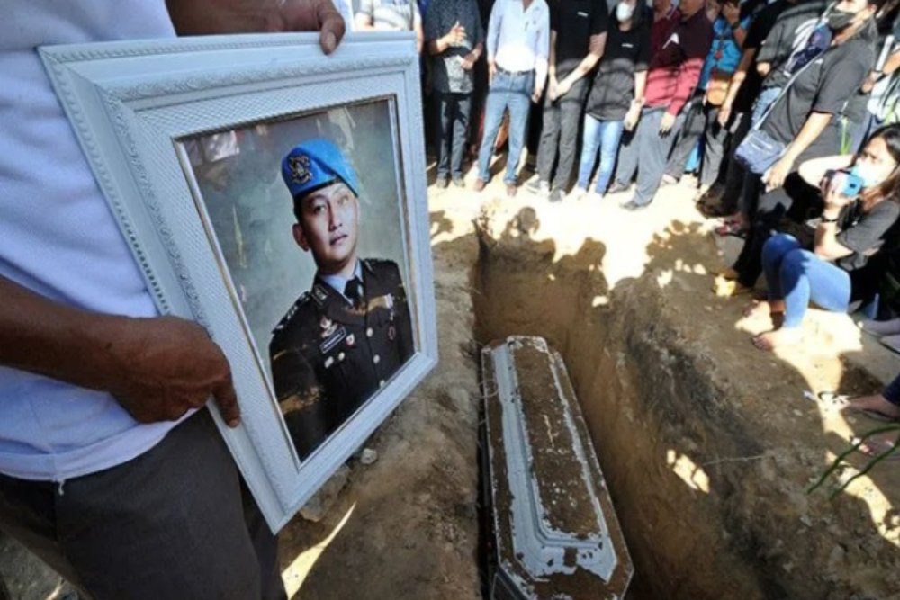 Kerabat memegang foto almarhum Brigadir Nofriansyah Yosua Hutabarat atau Brigadir J saat pemakaman kembali jenazah setelah autopsi ulang di Sungai Bahar, Muarojambi, Jambi, Rabu (27/7/2022)./Antara