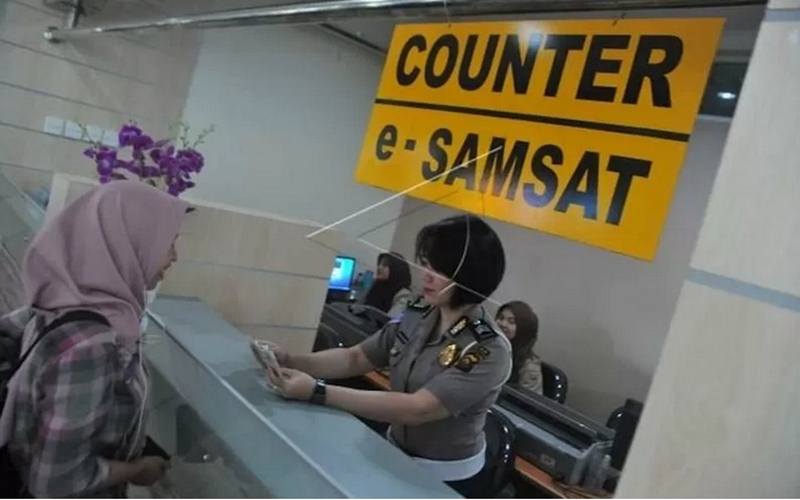 Petugas Samsat sedang melayani warga urus pajak kendaraan bermotor./Antara.