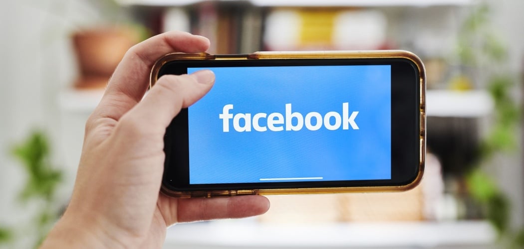 Logo Facebook terlihat di layar smartphone./Bloomberg-Gabby Jones