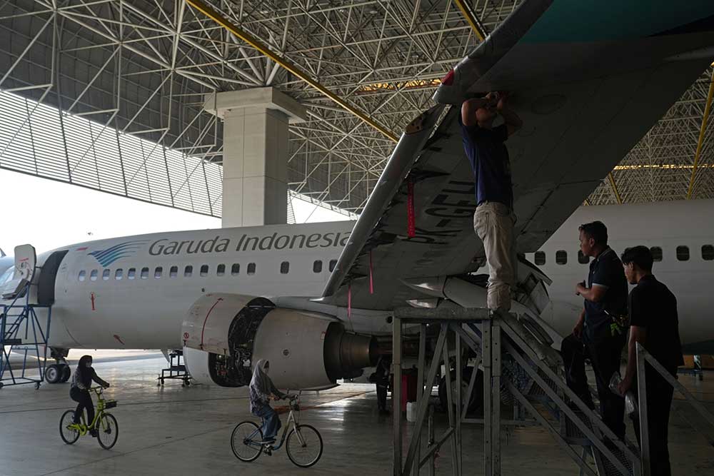 Karyawan melakukan perawatan pesawat milik PT Garuda Indonesia di dalam hanggar di Bandara Internasional Soekarno-Hatta di Cengkareng, Banten, Kamis (30/6/2022). Bloomberg/ Dimas Ardian