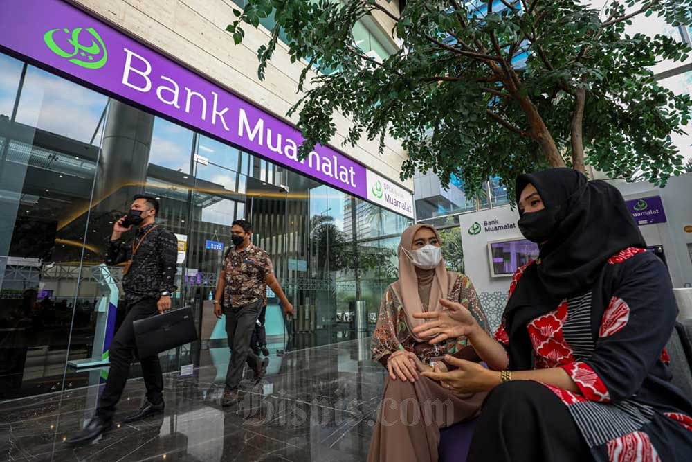 Karyawati beraktivitas di depan kantor cabang PT Bank Muamalat Indonesia Tbk. di Jakarta, Selasa (12/7/2022). /Bisnis-Abdurachman