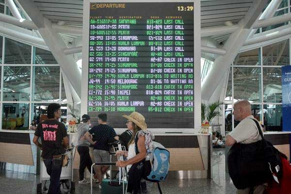 Calon penumpang pesawat mengamati jadwal penerbangan di kawasan Terminal Internasional Bandara Internasional I Gusti Ngurah Rai, Bali, Sabtu (23/9)./ANTARA-Fikri Yusuf
