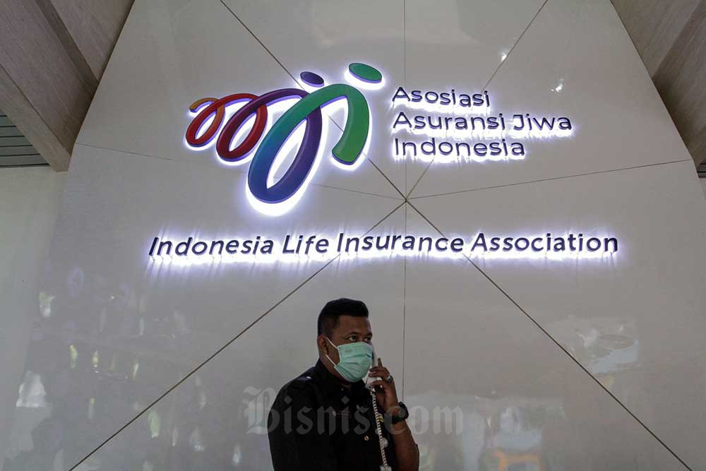 Petugas beraktivitas di dekat logo-logo asuransi di kantor Asosiasi Asuransi Jiwa Indonesia (AAJI), Jakarta, Selasa (23/8/2022). Bisnis/Fanny Kusumawardhani