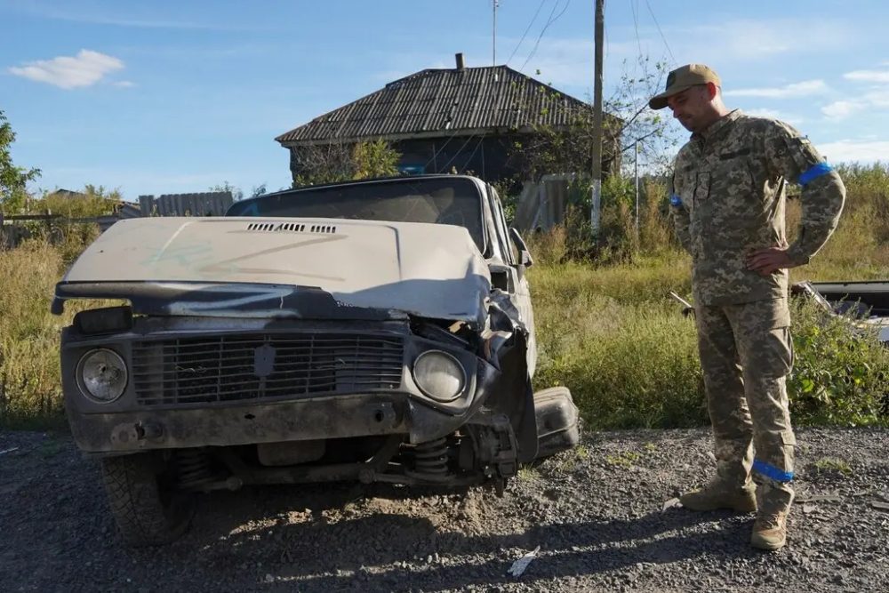Seorang tentara Ukraina berdiri di dekat sebuah mobil sipil di desa Grakovo di timur laut Ukraina pada Jumat (9/9/2022)/Vasiliy Zhlobsky via Shutterstock. 