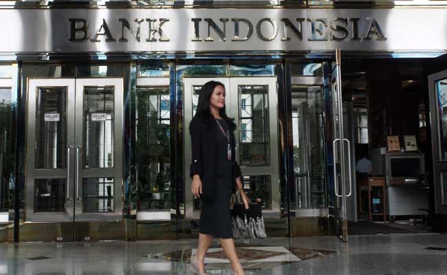 Karyawan melintas di dekat logo Bank Indonesia di Jakarta, Senin (3/2/2020).