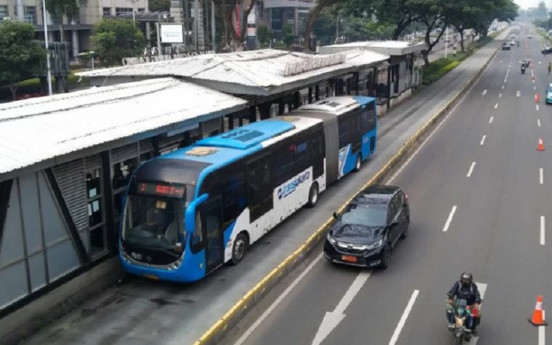 Bus TransJakarta berhenti di Halte Gelora Bung Karno untuk menaikkan dan menurunkan penumpang di Jakarta, Minggu (30/1/2022)./Antara