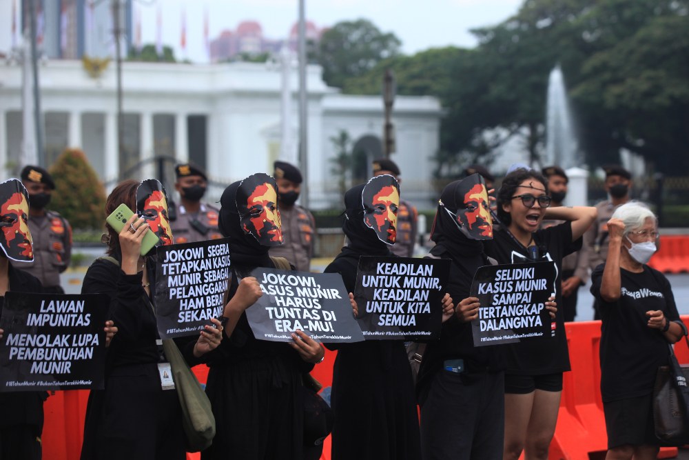Pegiat Hak Asasi Manusia (HAM) membawa poster dengan wajah Munir saat aksi Kamisan di depan Istana Merdeka, Jakarta, Kamis (8/9/2022). Aksi tersebut dilakukan untuk mengenang 18 tahun kematian Munir sekaligus mengingatkan pemerintah agar mengusut tuntas dalang di balik pembunuhannya. ANTARA FOTO/Reno Esnir/foc.
