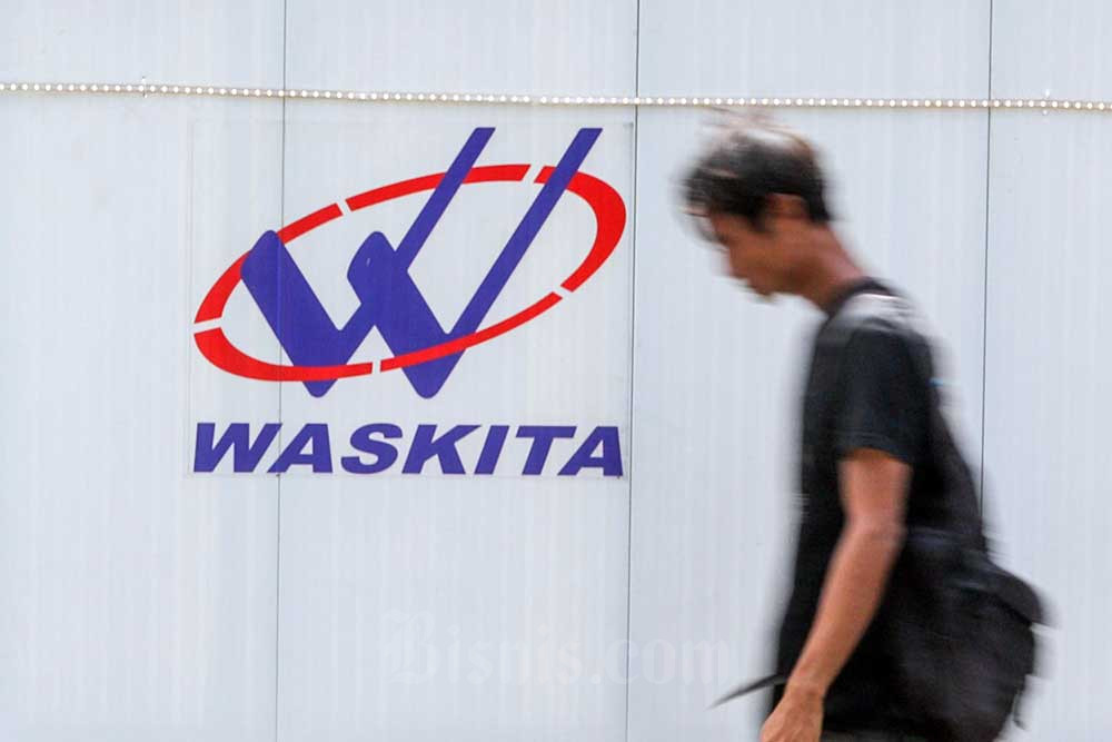 Warga melintas di dekat logo PT Waskita Karya (Persero) Tbk. (WSKT) di Jakarta, Senin (4/7/2022). Bisnis/Suselo Jati