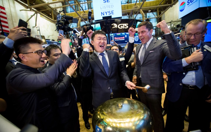 Chairman dan CEO Sea Ltd. Forrest Li (tengah) merayakan listing perusahaan teknologi tersebut di New York Stock Exchange (NYSE), AS, Jumat (20/10/2017)./Bloomberg-Michael Nagle