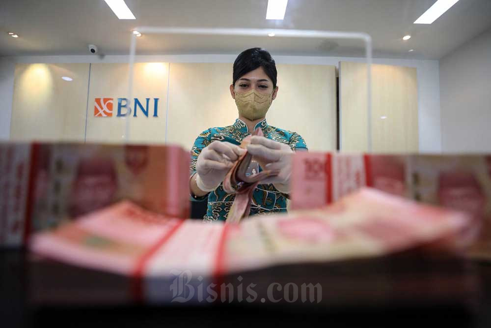Karyawan menghitung uang rupiah di salah satu kantor cabang BNI di Tangerang Selatan, Banten, Kamis (30/6/2022). Bisnis/Eusebio Chrysnamurti