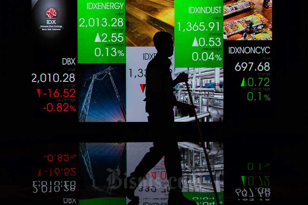 Karyawan melintas di dekat layar pergerakan indeks saham gabungan (IHSG) di Bursa Efek Indonesia, Jakarta, Senin (12/9/2022). Bisnis/Fanny Kusumawardhani