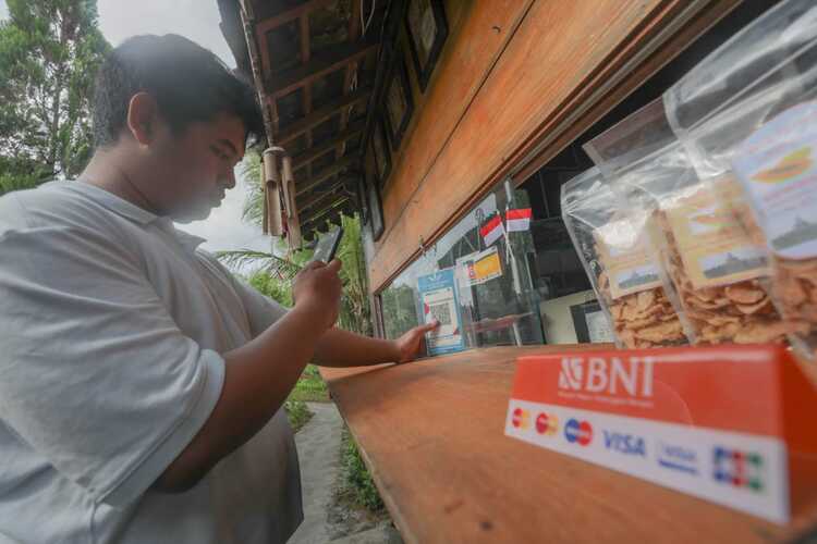 Tim Jelajah BUMN 2022 melakukan pembayaran menggunakan pindai QRIS dalam BNI Mobile Banking di Balkondes Karangrejo, Magelang, Jawa Tengah, Sabtu (17/9). / Himawan L Nugraha